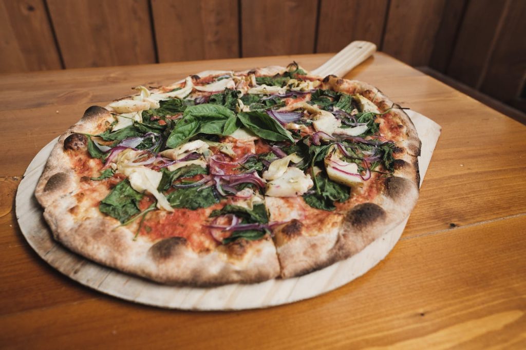 Delicious veggie pizza on a wooden board, showcasing fresh ingredients and rustic charm.